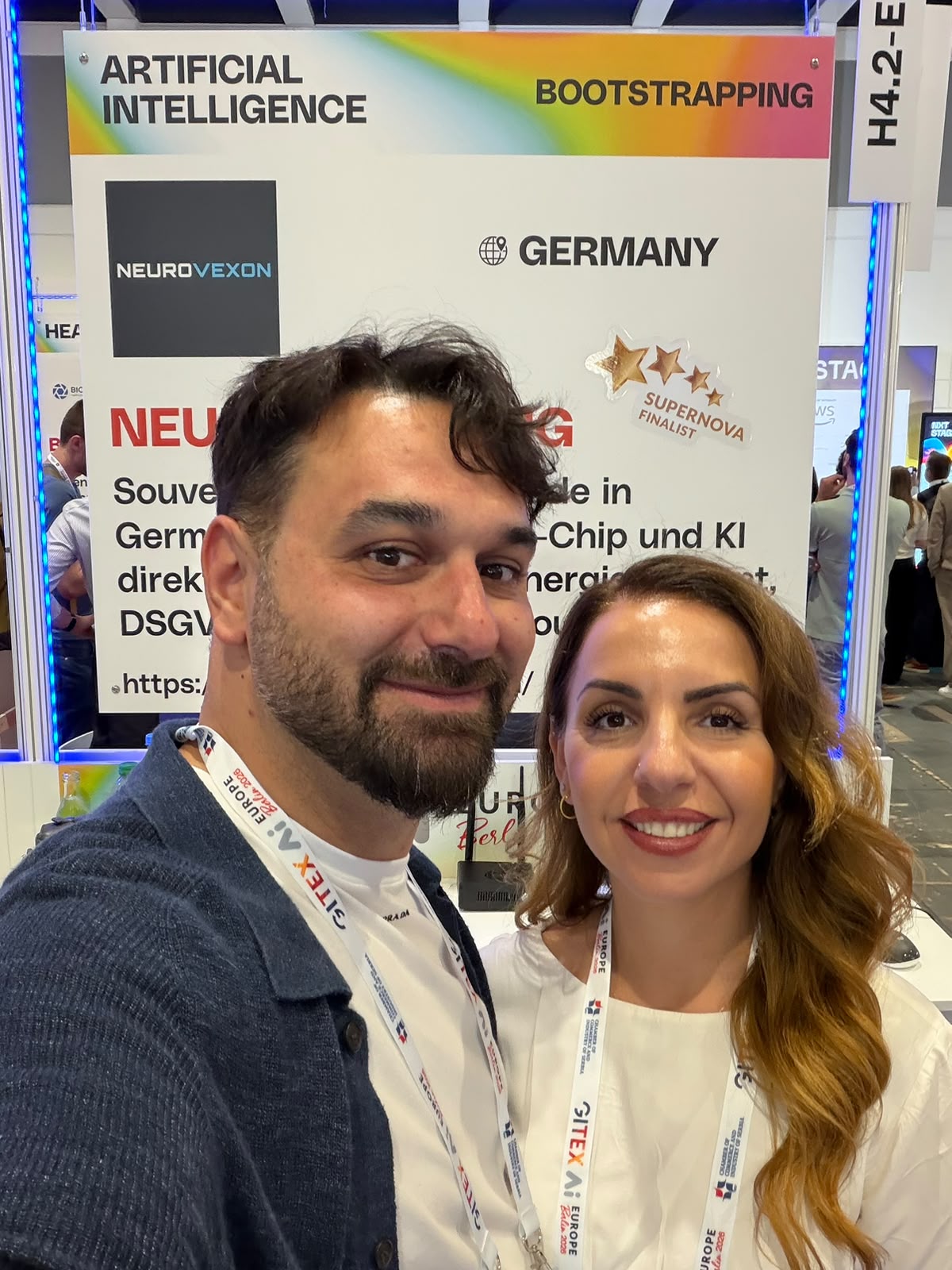 Our founding team at the NeuroVexon stand — with the Supernova Finalist badge.