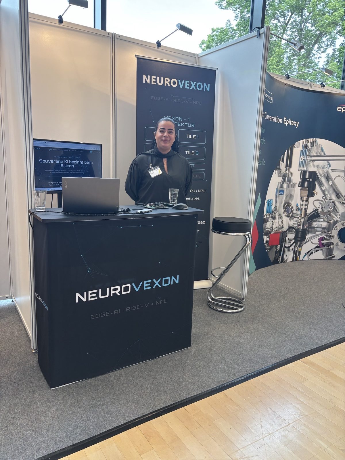 The NeuroVexon booth with the Vexon-1 prototype and the architecture overview.